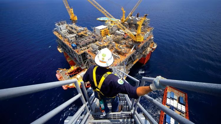 A man climbing down a ladder on an offshore platform
