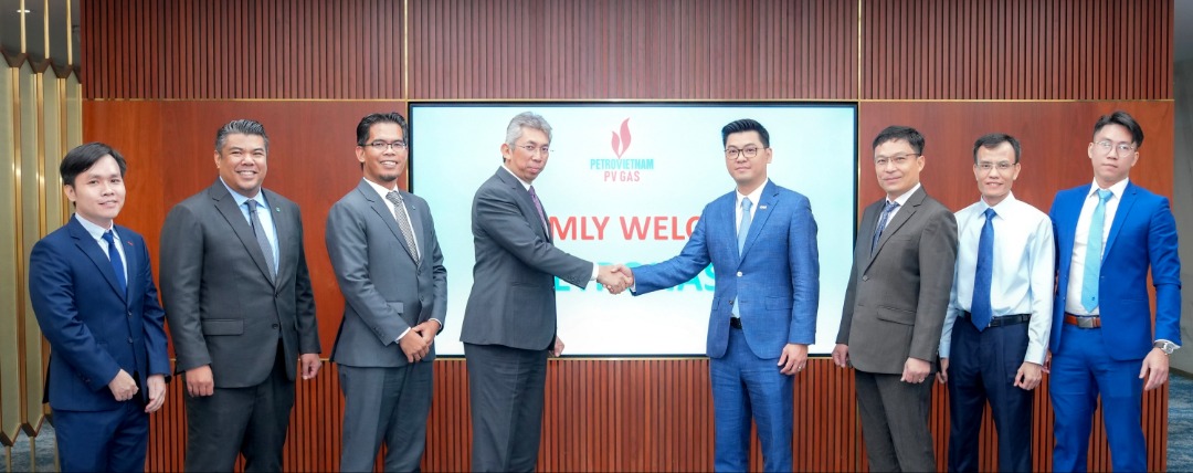 Two men shaking hands with several other men standing beside each