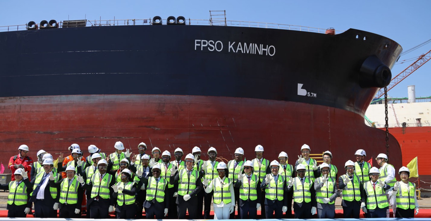 People standing in two lines in front of a large ship