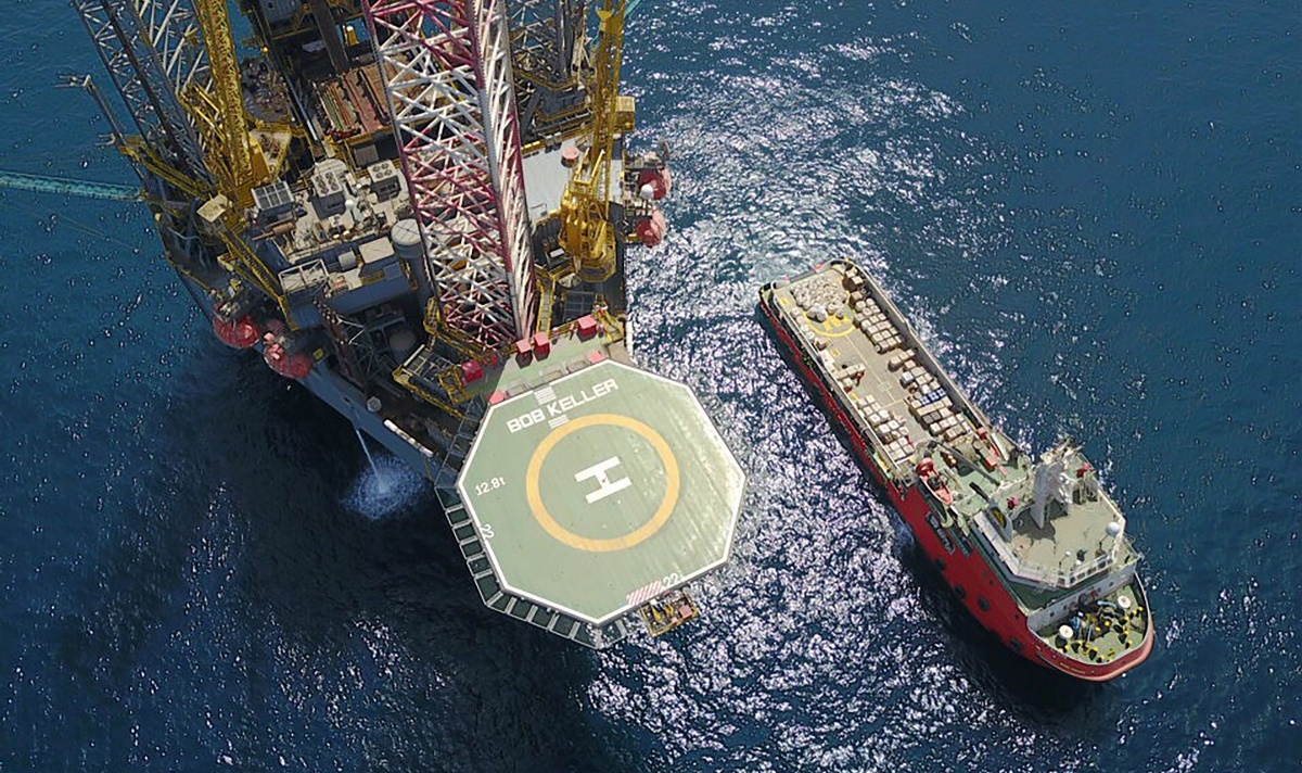Aerial view of an offshore rig with a smaller vessel next to it