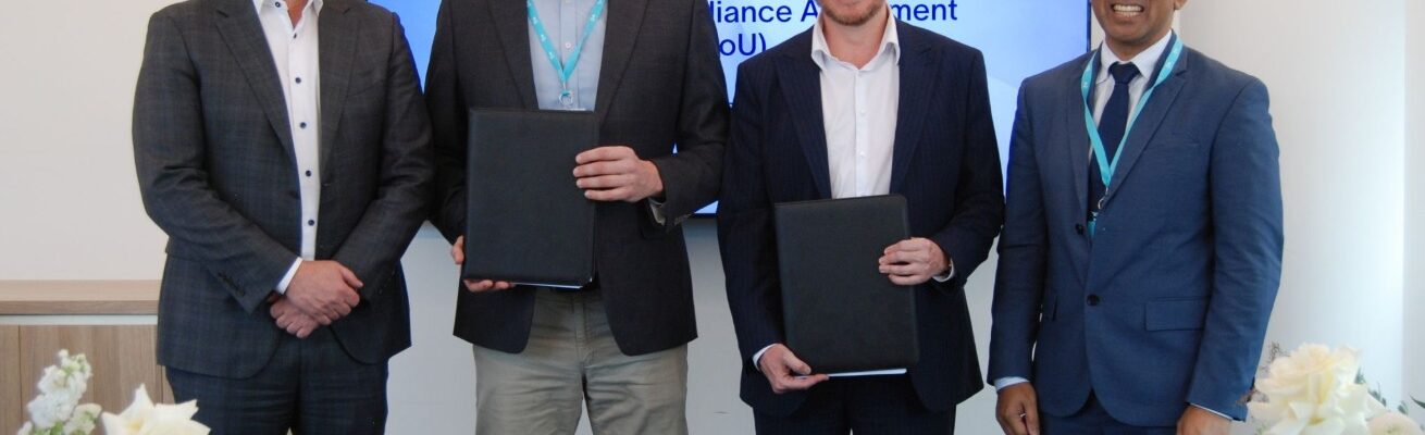 Four men standing and holding folders with signed documents
