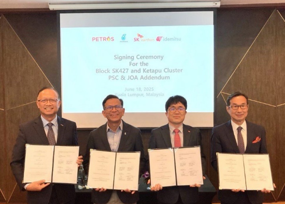 Four men holding documents at a signing ceremony