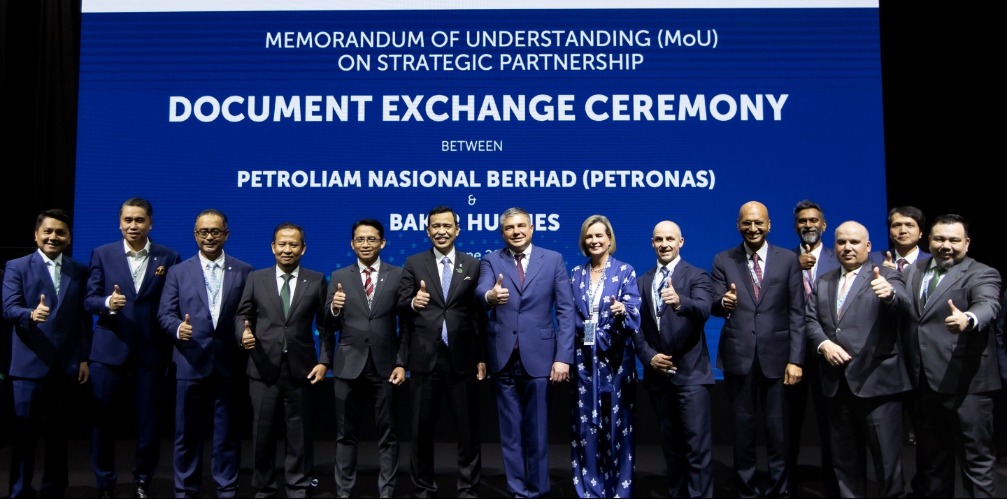 Several people standing on stage at an MoU signing ceremony
