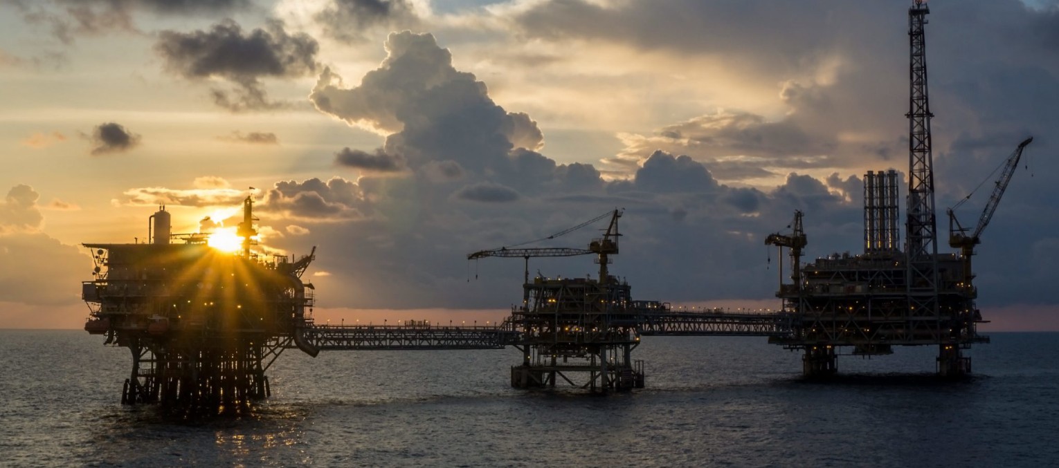 Three connected offshore platforms at sunset