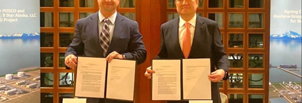 Two men holding documents at a commercial agreement signing