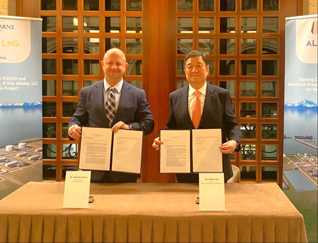 Two men holding documents at a commercial agreement signing